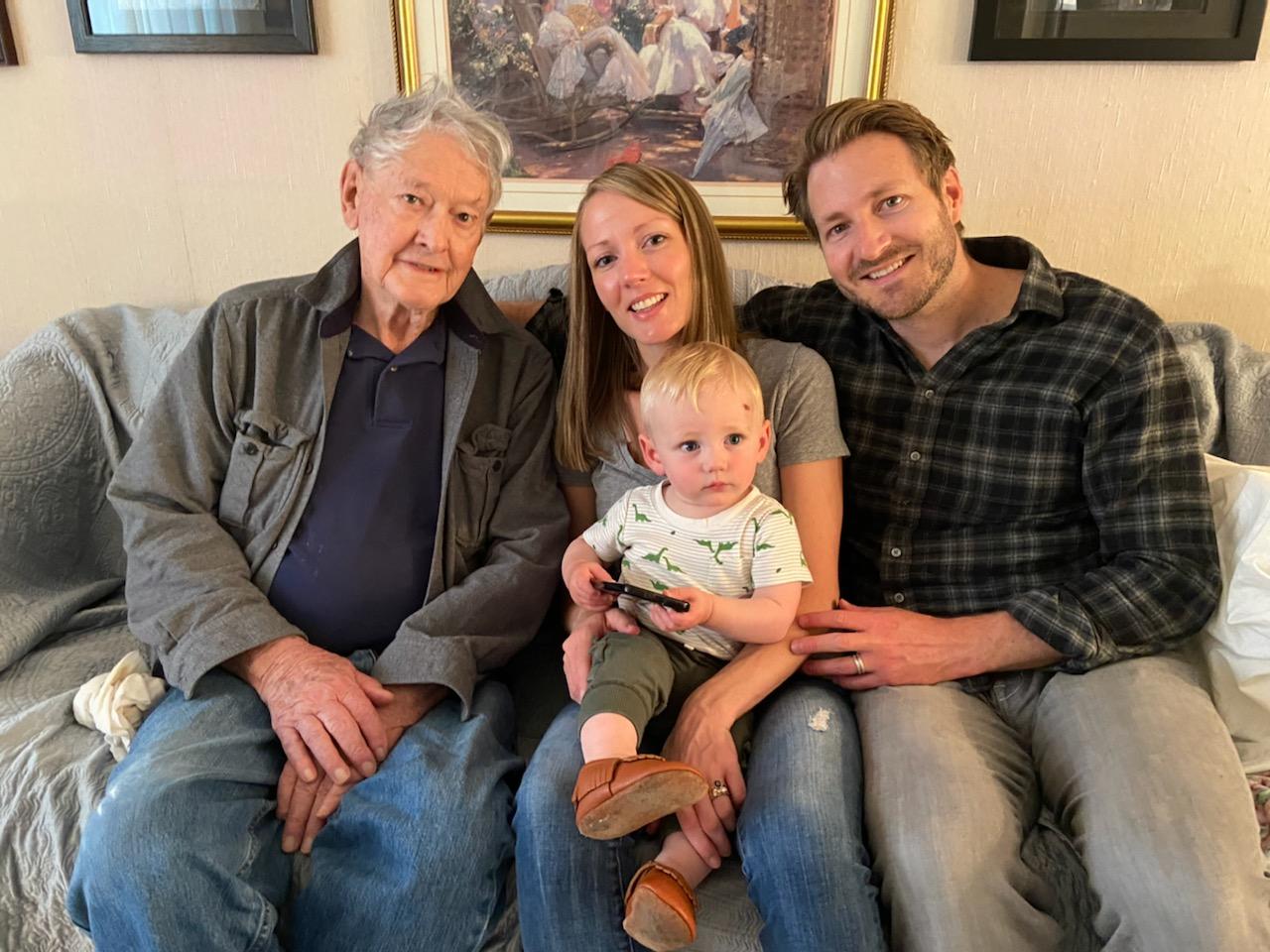 Great Grandpa Russ, Owen, Katie, and Jeff on the couch at Russ's house.