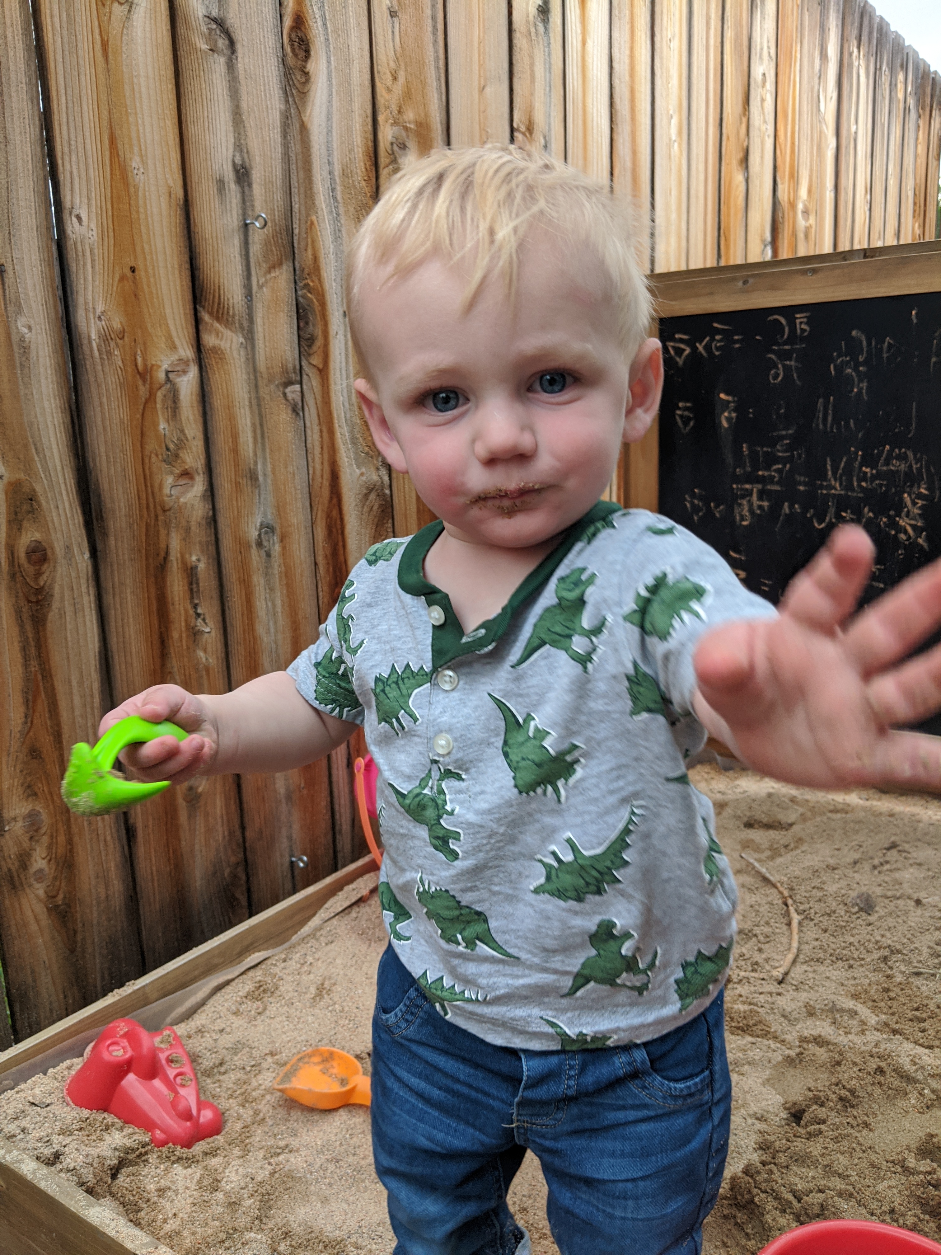 Owen eating sand in his sandbox.